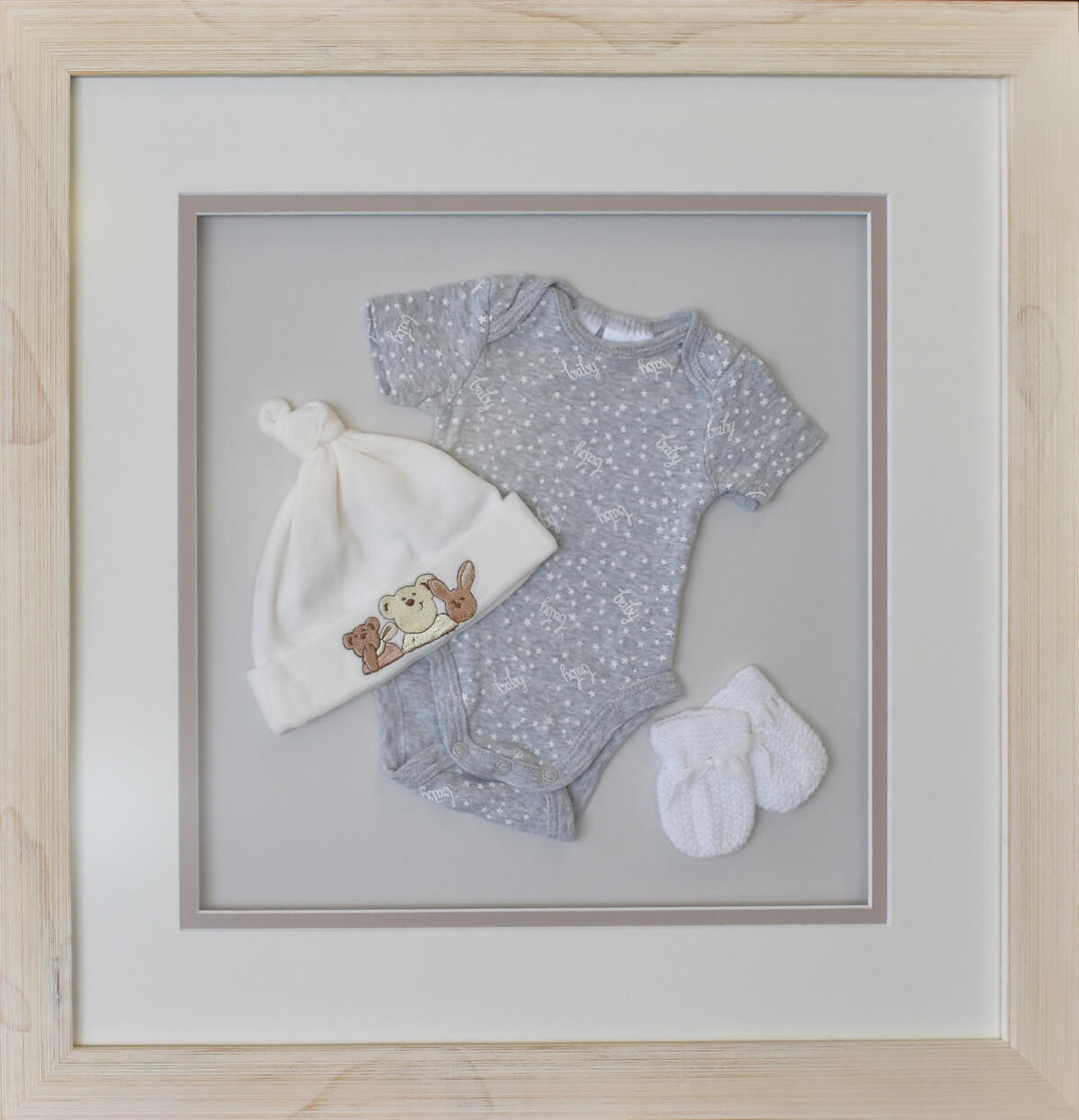 Baby onesie, beanie and socks floated in frame with double mats